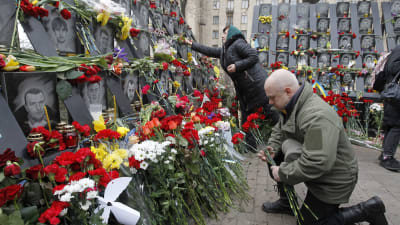 Ukrainare lägger blommor vid ett minnesmärke för de som dog under Maidanupproret 2014