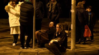 Folk samlas mitt i natten utomhus i Albaniens huvudstad Tirana efter ett jordskalv.