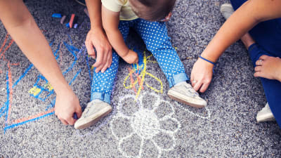Barn som ritar på asfalt