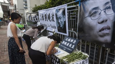 Människor i Hongkong lämnar sina kondoleanser efter Liu Xiaobos död. Ett foto på änkan Liu Xia i förgrunden. 14.7.2017.