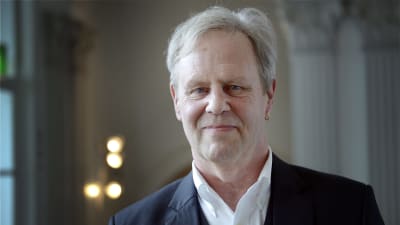 Porträtt av Göran Djupsund i vit skjorta och kavajrock.
