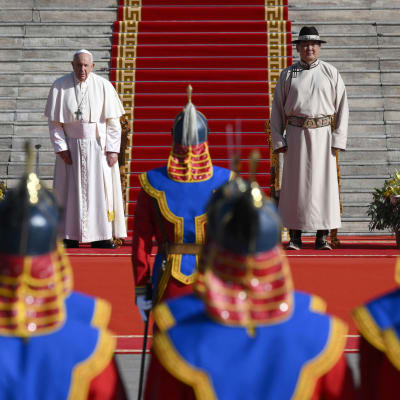 Paavi seisoo vasemmalla ja Mongolian presidentti oikealla parlamenttitalon rappujen edessä.