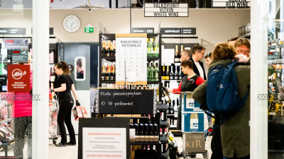 Ihmisiä Alkossa.