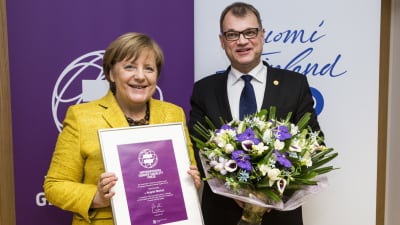 Juha Sipilä gav priset till Angela Merkel i Bryssel.