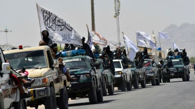 Taliban sotilaita liputtavat autoista.