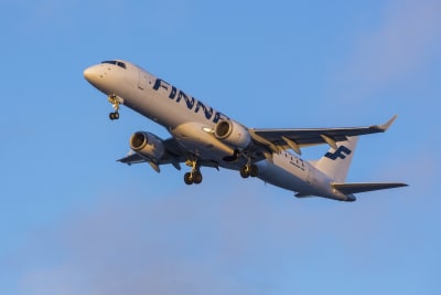 Ett Finnairplan i luften. I bakgrunden blå himmel.