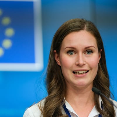Sanna Marin med EU:s flagga i bakgrunden