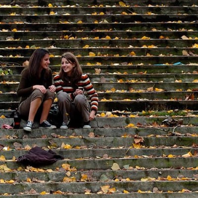 Kaksi tyttöä istuu portailla.
