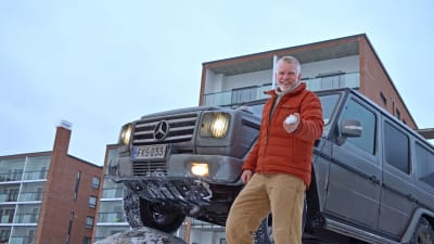 Pata Degerman kramar en snöboll i handen, framför sin terrängbil.
