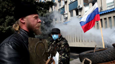 Ortodox präst utanför en ockuperad byggnad i Lugansk.