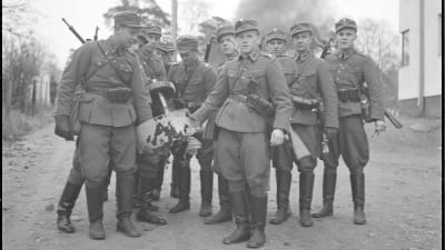 Finska soldater håller i en flygplansmotor från ett nerskjutet sovjetiskt flygplan i Munksnäs i Helsingfors under vinterkriget 1.12.1939.