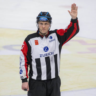 Jääkiekkoerotuomari Anssi Salonen nostaa kätensä ylös.