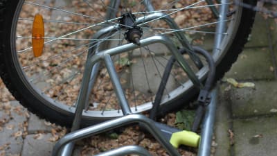 Ett cykelhjul som är fastlåst i en cykelställning. Någon har stulit själva cykeln.
