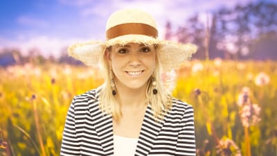 Mikaela Kosk står på en sommarhäng med en solhatt på huvudet.