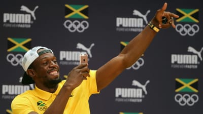 Usain Bolt håller en Iphone i handen.