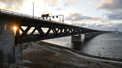 Solen går ner över Öresundsbron mellan Sverige och Danmark
