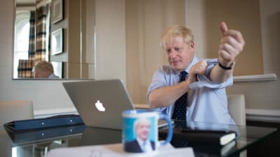 Boris Johnson ses kavla upp ärmarna vid en dator. 