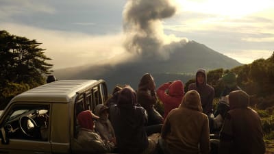 Människor tittar på när stora mängder rök stiger upp från vulkanen Turrialba i Costa Rica.
