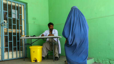 Kvinna k burqa besöker tillfälligt hälsocenter för flyktingar i Kabul.