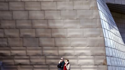 Två turister utanför Guggenheim Bilbao.