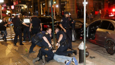 Poliser griper en demonstrant som ligger på marken