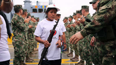 kvinna från rebellgruppen ELN ger över sitt vapen till militären