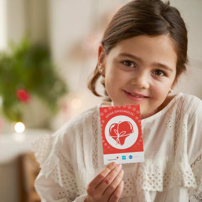flicka håller i ett presentkort från Jul i sinnet-insamlingen