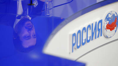 Matteo Salvinis ansikte reflekteras i ett glasbord i ryska flaggans färger.