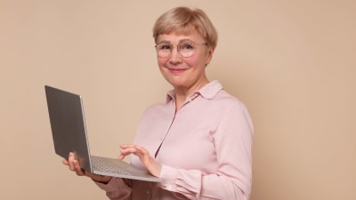 Leende kvinna med dator i famnen