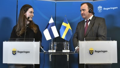 Sanna Marin och Stefan Löfven tittar på varandra under en presskonferens i Harpsund.