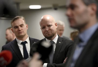 Atte Harjanne, Jussi Saramo och Kai Mykkänen står på rad. Mykkänen talar med journalister, de andra ser på.