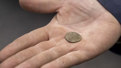 Ett mynt från 1715 som hittats under en arkeologisk utgrävning.