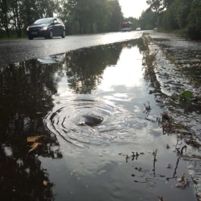 Sateen jälkeen lammikon vesi valuu pyörteenä katukaivoon.