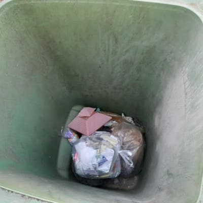 Tavanomainen kotipihan sekajäteroskis, pohjalla neljän viikon jätteet eli muutama nyytti.