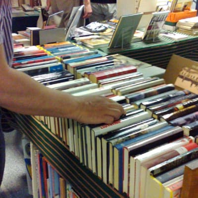 Henkilö tutkii vanhoja myytäviä kirjoja