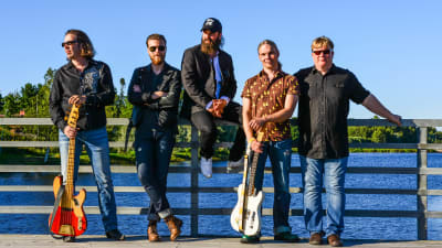 Wentus Blues Band. Medlemmmarna står på en brygga med hav i bakgrunden