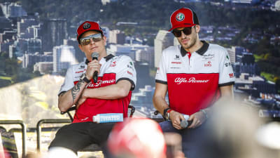 Kimi Räikkönen och Antonio Giovinazzi sitter på en scen.