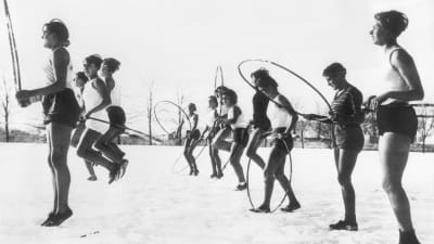 Flickor i Berlin på 30-talet som gör skolgymnastik, utomhus i snön iklädda endast shorts och linne.