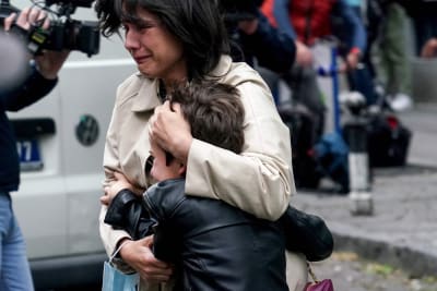 En förälder med ett barn efter masskjutningen på en skola i Belgrad den 3 maj 2023.  