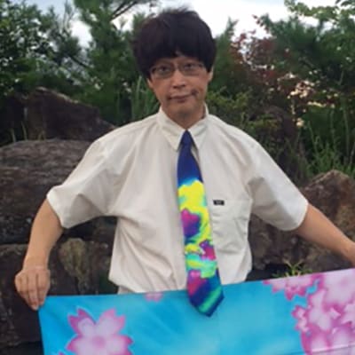 Masaki Araki esittelee Elina Wätön suunnittelemaa kravattia ja huivia
