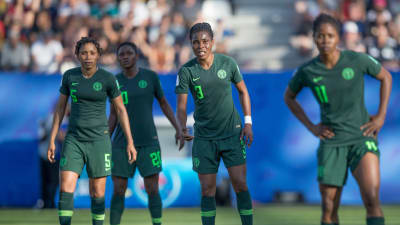 Nigerianska damlandslagsspelare ser besviket framåt.
