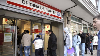 En grupp män köar in till arbetskraftsbyrån i Madrid, Spanien.