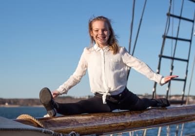 Emma Dönnes gör spagat på en segelskutas bom.
