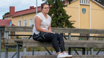 Kulstötaren Jessica Meriheinä sitter på läktaren vid Liljendal sportplan.
