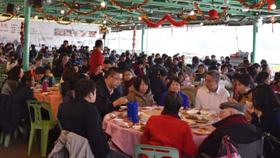 Folk sitter vid matbord i en kinesisk restaurang