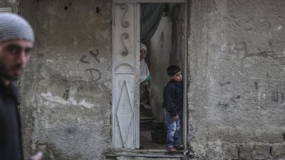 Syriska barnen Yasser och Heba tittar ut från sitt hem i Damaskus i Syrien 22 februari 2016.