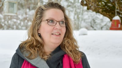 Annika Gustafsson-Flinck utomhus under vintertid. I bakgrunden syns träd och mark täckt av snö. 