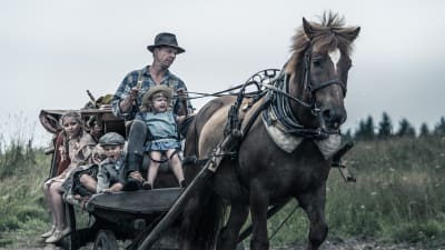 Filmbild av man och barn på hästkärra