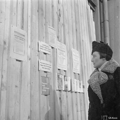 En kvinna i Helsingfors läser om freden i mars, 1940