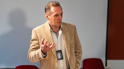 Polisen Hannu Kortelainen står civilklädd i ett mötesrum på polisstationen.